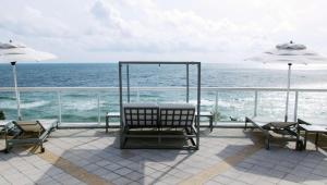 a patio with chairs and umbrellas and the ocean at Hilton Fort Lauderdale Beach Resort in Fort Lauderdale