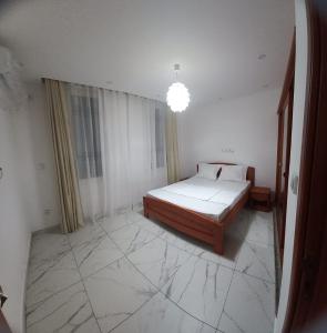 a bedroom with a bed in a room with marble floors at Beau T2 Nouvelle Route bastos Yaoundé in Yaoundé