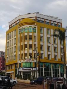 a yellow building with a palm tree in front of it at Beau T2 Nouvelle Route bastos Yaoundé in Yaoundé