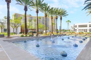 uma piscina com palmeiras em frente a um hotel em Embassy Suites by Hilton Anaheim-Orange em Anaheim