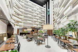 restauracja ze stołami i krzesłami oraz dużym sufitem w obiekcie Embassy Suites by Hilton Anaheim-Orange w mieście Anaheim