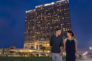 a man and a woman standing in front of a building at Hilton San Diego Bayfront in San Diego