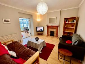 a living room with a couch and a fireplace at 3 bed penthouse flat with conservatory & roof terrace - city views in Bristol