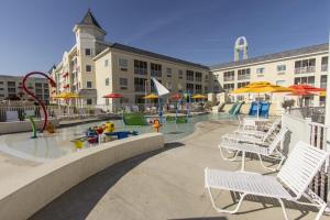 a pool with chairs and umbrellas and a playground at Cedar Point Hotel Breakers in Sandusky