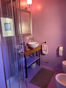 uma casa de banho com um lavatório e uma cabina de duche em vidro. em matana b&b em Carmignano