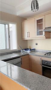 a kitchen with a sink and a counter top at magnifique appartement de trois chambres avec vue sur le golf et la mer Marina Asilah in Asilah