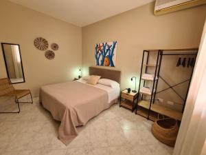 a bedroom with a bed and a chair in it at Casa Calilla - 30m dal mare in Lampedusa