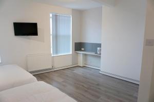 a white room with a bed and a desk in it at Townsend lane accommodation in Liverpool