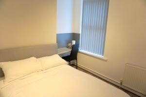 a bedroom with a bed and a desk and a window at Townsend lane accommodation in Liverpool