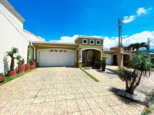 una casa grande con un garaje delante en Beautiful home w/ backyard, AC - close to airport, en Brasil