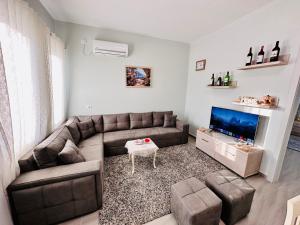 a living room with a couch and a flat screen tv at Rrjolli View Beach in Velipojë