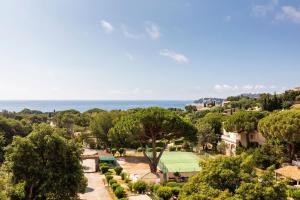 - une vue sur un parc avec l'océan en arrière-plan dans l'établissement Hôtel du Parc Cavalaire sur Mer, à Cavalaire-sur-Mer