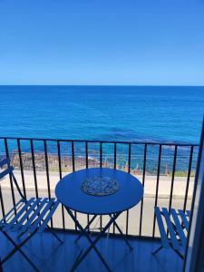 a table and chairs on a balcony with the beach at Scinniamare in Cefalù
