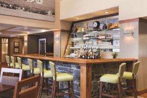 eine Bar mit gelben Barhockern in einem Restaurant in der Unterkunft Hampton Inn & Suites Lake George in Lake George