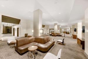 un vestíbulo con un sofá de cuero marrón y sillas en Hilton Anaheim, en Anaheim