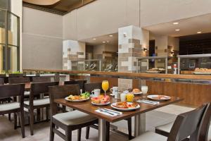 a dining room with a table with plates of food at Embassy Suites by Hilton Los Angeles Downey in Downey