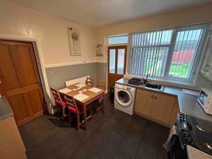 a kitchen with a table and a washing machine at Lovely house & driveway parking in Kidsgrove