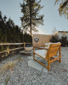 a wooden chair sitting in a yard next to a fence at Dreamy Airstream Hideaway with Hot Tub in Gibsons