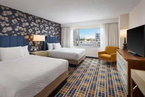 a hotel room with two beds and a television at Embassy Suites by Hilton Atlanta Buckhead in Atlanta
