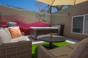 un patio con mesa, sillas y bañera en East Downtown Desert Chic Casita-Hot Tub-Pet Friendly-No Pet Fees!, en Albuquerque