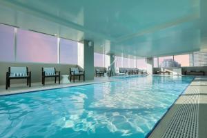 a large swimming pool in a building with windows at Hilton Cleveland Downtown in Cleveland