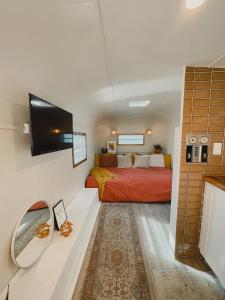 a bedroom with a bed and a television in it at Dreamy Airstream Hideaway with Hot Tub in Gibsons