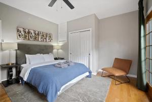 a bedroom with a bed with a blue blanket and a chair at StayRafa At 261 4R in Philadelphia