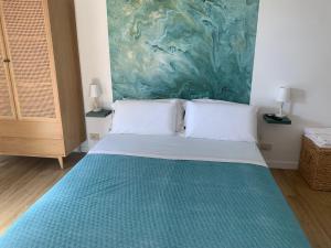 a bed in a room with a painting on the wall at Casa VerdeMare in Lido di Ostia
