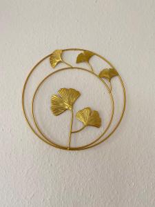 a gold hanger with a leaf design on a wall at Harmony Apartment, your holiday home in Rust with balcony & river-view, 5min to Europa-Park in Rust