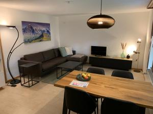 uma sala de estar com um sofá e uma mesa em Apartment EigerView em Grindelwald