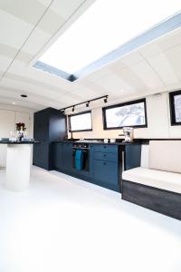 a kitchen and living room in a boat at Blue Waterside Haven Charming 2 Bedroom Boat on Staines Rd Chertsey in Chertsey