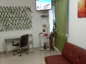 a living room with a couch and a television at EstanciaS ALELI comodo apart/std, Aero/pto,t/Nal de transporte in Cali