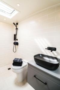 a bathroom with a black sink and a toilet at Blue Waterside Haven Charming 2 Bedroom Boat on Staines Rd Chertsey in Chertsey