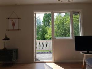 una sala de estar con una puerta abierta a una terraza en Villa i naturskönt läge Järvsö, en Järvsö