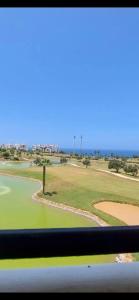 una ventana con vistas al campo de golf en magnifique appartement de trois chambres avec vue sur le golf et la mer Marina Asilah, en Asilah