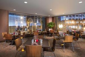 um restaurante com mesas e cadeiras e uma grande janela em Hilton Parc 55 San Francisco Union Square em São Francisco