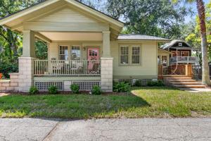 a yellow house with a porch and a balcony at Flagler Cottage - 1 Block to Historic District in St. Augustine
