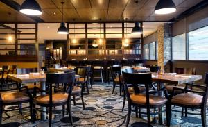 um restaurante com mesas e cadeiras e um bar em DoubleTree by Hilton Hotel & Suites Jersey City em Jersey City