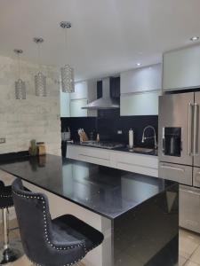 a kitchen with a black and white counter top at Casa Elegante cerca aeropuerto y zona turistica in Canovanas