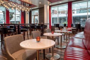 un restaurant avec des tables, des chaises et des fenêtres dans l'établissement Embassy Suites By Hilton Seattle Downtown Pioneer Square, à Seattle