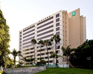 圣地亚哥Embassy Suites by Hilton San Diego La Jolla的一座前面有棕榈树的大楼