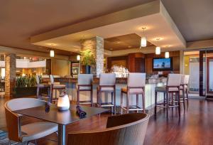 a restaurant with a bar with chairs and tables at Embassy Suites by Hilton San Diego La Jolla in San Diego