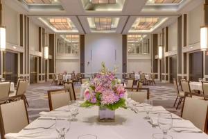 a banquet hall with a table with a vase of flowers at Hilton Newark Airport in Elizabeth