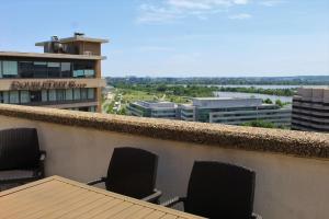 a balcony with two chairs and a view of a city at DoubleTree by Hilton Washington DC – Crystal City in Arlington
