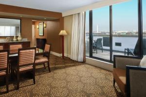 アーリントンにあるダブルツリー ホテル ワシントン DC - クリスタル シティーのテーブルと椅子、大きな窓が備わるホテルルームです。