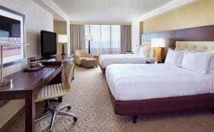 a hotel room with two beds and a desk at DoubleTree by Hilton Washington DC – Crystal City in Arlington