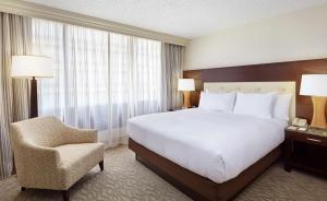 a hotel room with a large bed and a chair at DoubleTree by Hilton Washington DC – Crystal City in Arlington