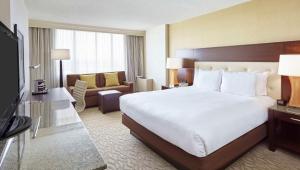 a hotel room with a large bed and a living room at DoubleTree by Hilton Washington DC – Crystal City in Arlington