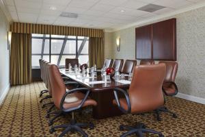 a conference room with a long table and leather chairs at DoubleTree by Hilton Washington DC – Crystal City in Arlington