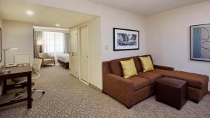 a living room with a couch and a desk in a hotel room at DoubleTree by Hilton Washington DC – Crystal City in Arlington